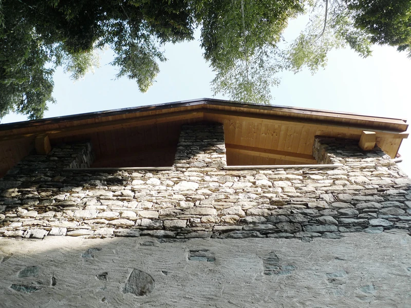 Neue Dachkonstruktion mit Holzsparren auf der Natursteinmauer