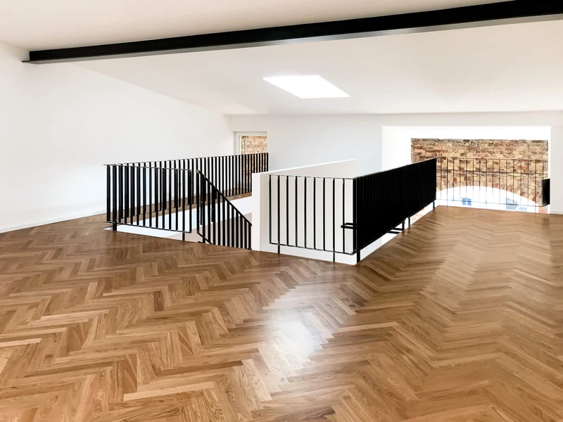 Galerieebene mit Oberlicht, Stahlgeländer und Fischgrätparkett