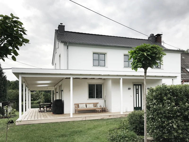 Gartenansicht des Landhauses mit Veranda und Kugelbaum