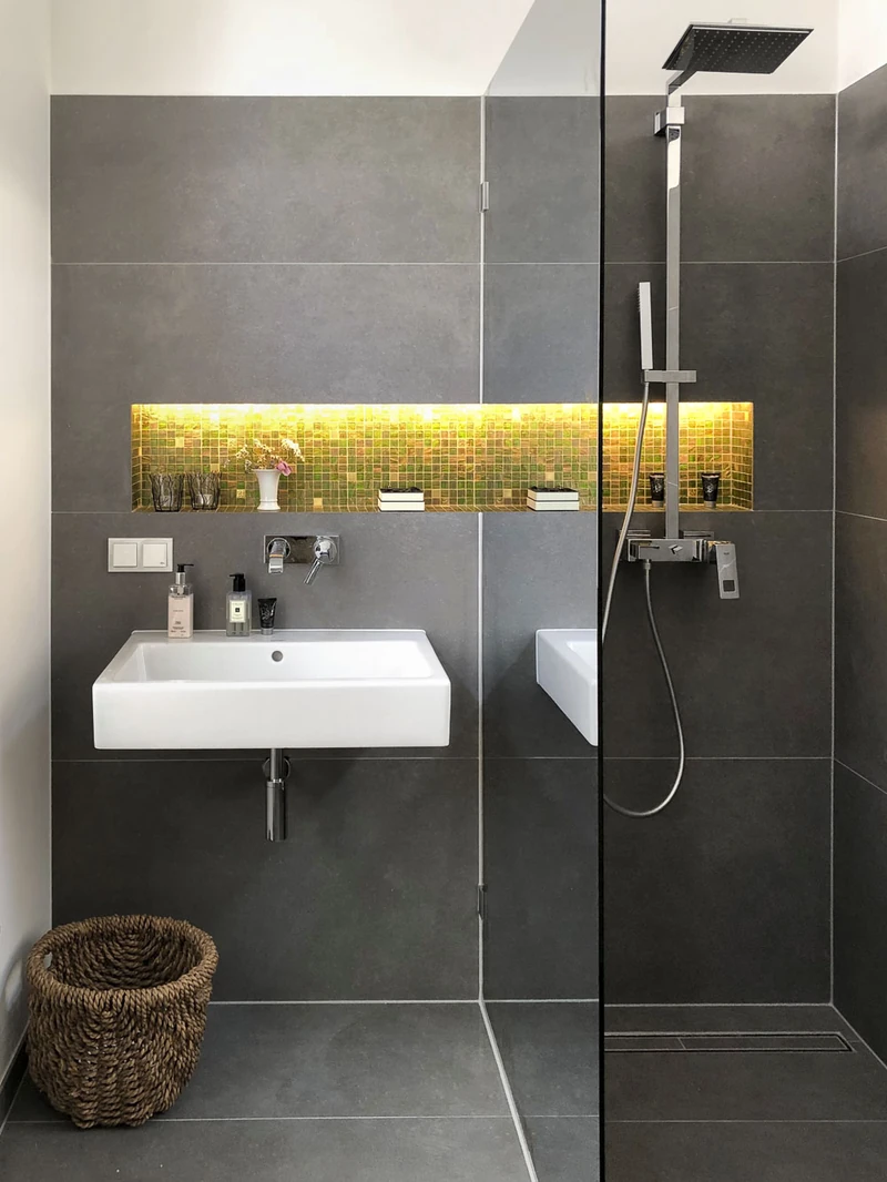 Dusche mit anthrazitfarbenen Fliesen und beleuchteter Nische