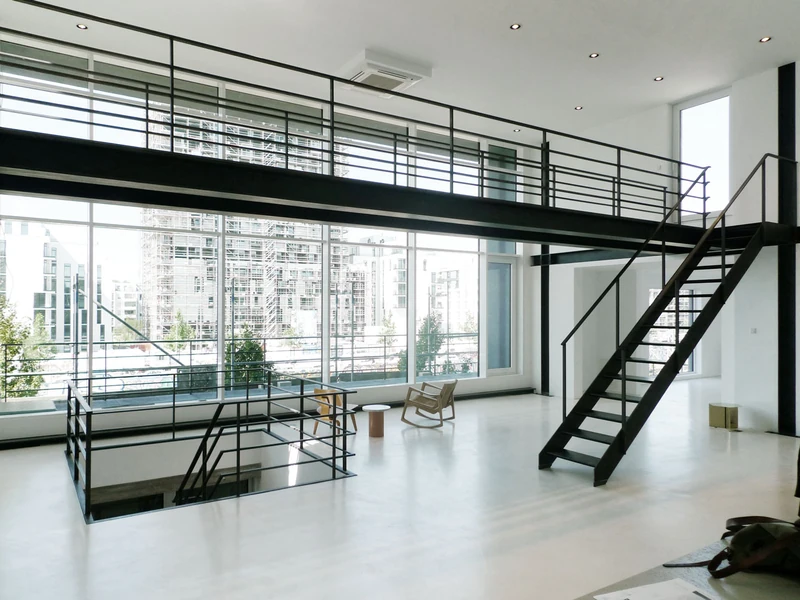 Galerie mit Stahltreppe vor raumhoher Glasfassade