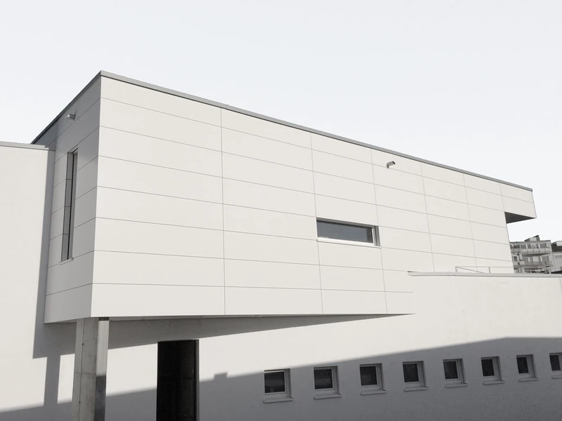 Auskragendes Obergeschoss mit Plattenfassade über schmalen Fensterbändern