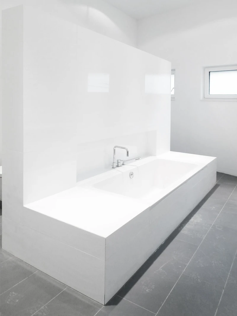 Freistehende weiße Badewanne im hellen Bad
