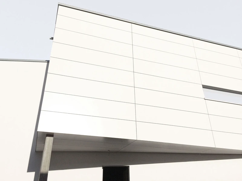 Detail der hellen Plattenfassade am auskragenden Baukörper